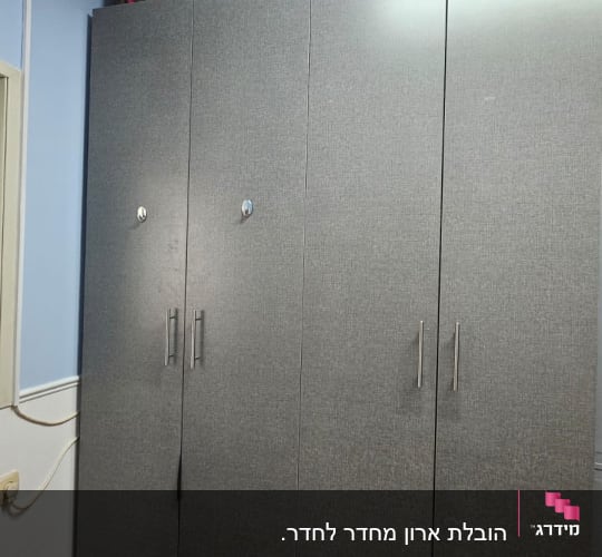 מזוודה צבעונית על ארון בגדים אפור